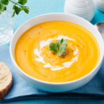 Pumpkin and carrot soup with cream and parsley
